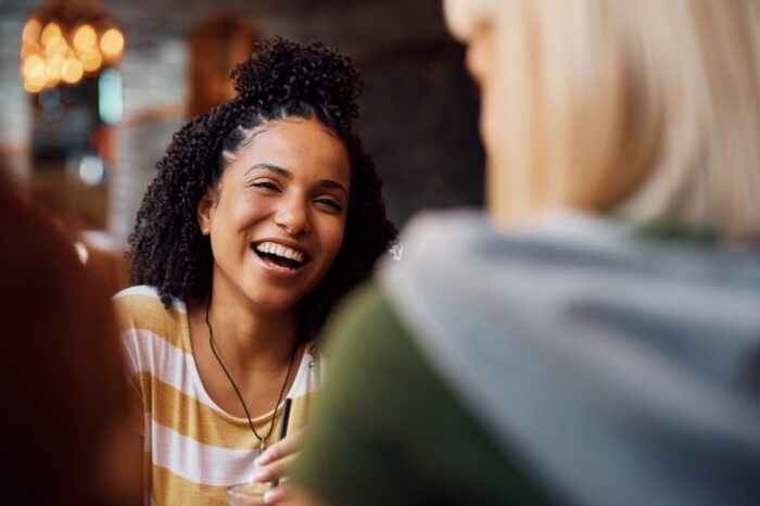 young-black-woman-laughing-while-being-with-her-fr-2024-12-13-17-09-32-utc